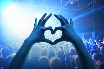 Image showing The silhouettes of concert crowd in front of bright stage lights