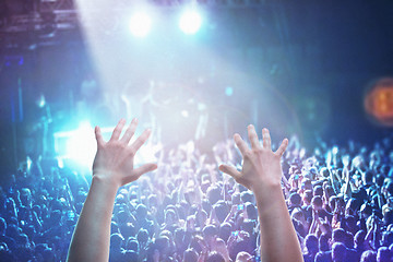 Image showing The silhouettes of concert crowd in front of bright stage lights