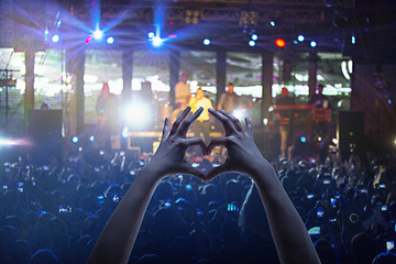 Image showing The silhouettes of concert crowd in front of bright stage lights