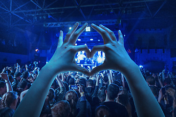 Image showing The silhouettes of concert crowd in front of bright stage lights