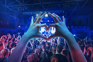 Image showing The silhouettes of concert crowd in front of bright stage lights