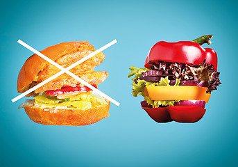 Image showing The healthy sandwich with fresh pepper, onion, salad lettuce and unhealthy harmful hamburger