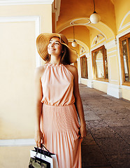 Image showing young pretty smiling woman in hat with bags on shopping at store