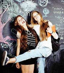 Image showing back to school after summer vacations, two teen real girls in classroom with blackboard painted together, lifestyle people concept