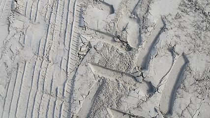 Image showing Sandy background with prints of wheels and footprints