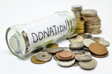 Image showing Donation lable in a glass jar with coins spilling out