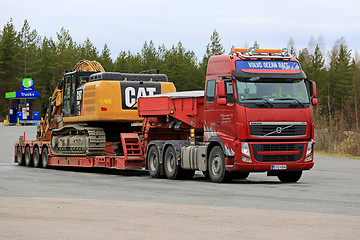 Image showing Volvo FH Semi Hauls Cat Excavator on Flat Trailer 