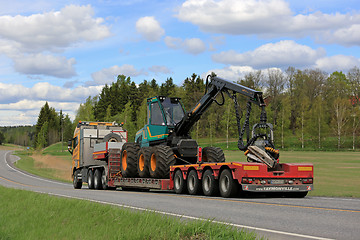 Image showing Semi Truck Transports Forestry Harvester at Spring