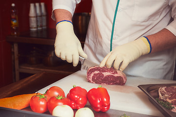 Image showing Chef cutting meat