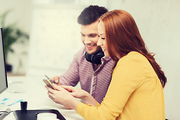 Image showing smiling creative team with smartphones at office
