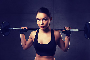 Image showing young woman flexing muscles with barbell in gym