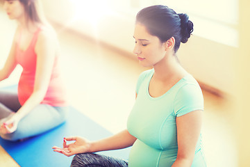 Image showing happy pregnant women exercising yoga in gym