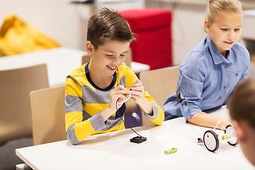 Image showing happy children building robots at robotics school