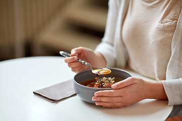 Image showing woman eating pumpkin cream soup at restaurant