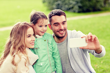 Image showing happy family taking selfie by smartphone outdoors