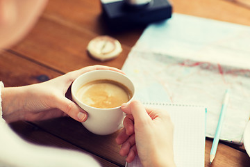 Image showing close up of hands with coffee cup and travel stuff