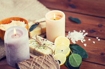 Image showing close up of natural soap and candles on wood