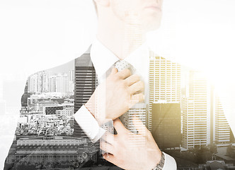 Image showing close up of man adjusting his tie