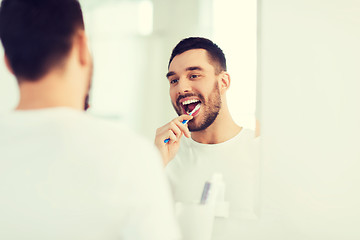 Image showing man with toothbrush cleaning teeth at bathroom