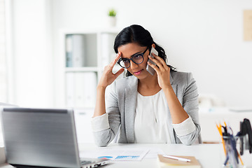 Image showing stressed businesswoman with smartphone at office