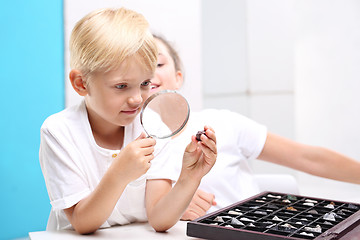 Image showing Steatite, mineral. Geography at school. Children watching minerals under the microscope