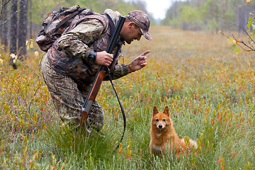 Image showing hunter with dog on the swamp