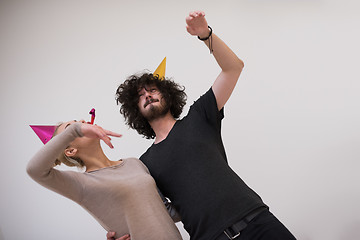 Image showing couple in party hats blowing in whistle