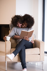 Image showing multiethnic couple hugging in front of fireplace