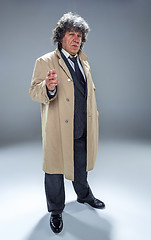 Image showing The senior man as detective or boss of mafia on gray studio background