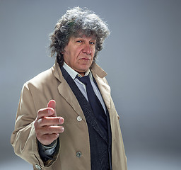 Image showing The senior man as detective or boss of mafia on gray studio background