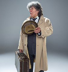 Image showing The senior man as detective or boss of mafia on gray studio background