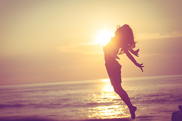 Image showing Happy little girl  jumping on the beach