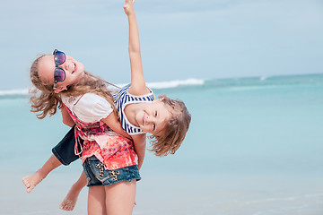 Image showing Sister and brother playing on the beach at the day time.