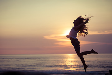 Image showing Happy little girl  jumping on the beach