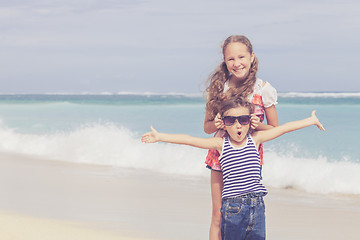 Image showing Sister and brother playing on the beach at the day time.