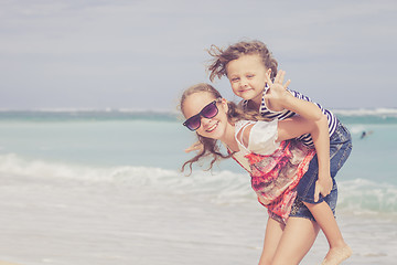 Image showing Sister and brother playing on the beach at the day time.