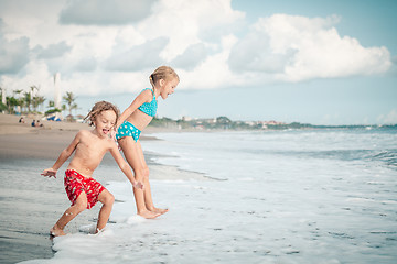 Image showing Sister and brother playing on the beach at the day time.