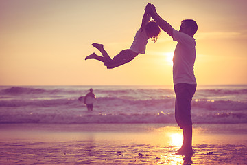 Image showing Father and son playing on the beach at the sunset time.