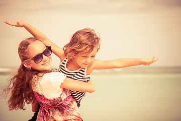 Image showing Sister and brother playing on the beach at the day time.