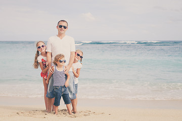 Image showing Father and children playing on the beach at the day time.