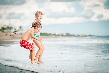 Image showing Sister and brother playing on the beach at the day time.