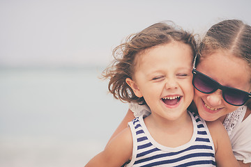 Image showing Sister and brother playing on the beach at the day time.