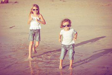 Image showing Sister and brother playing on the beach at the day time.