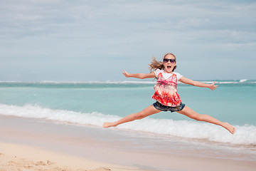 Image showing Happy teen girl  jumping on the beach