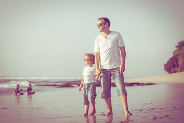 Image showing Father and son playing on the beach at the day time.