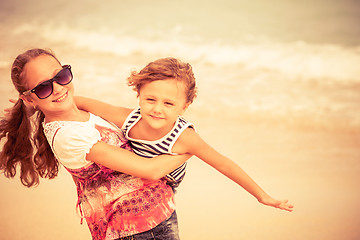 Image showing Sister and brother playing on the beach at the day time.