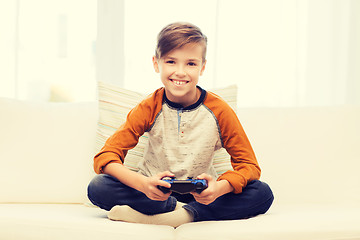 Image showing happy boy with joystick playing video game at home