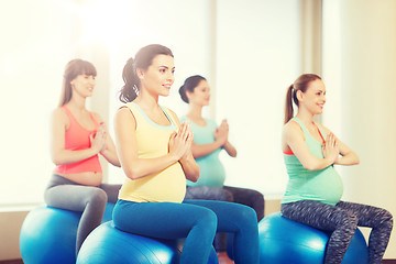 Image showing happy pregnant women exercising on fitball in gym