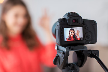 Image showing woman with camera recording video at home