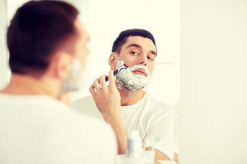 Image showing man shaving beard with razor blade at bathroom